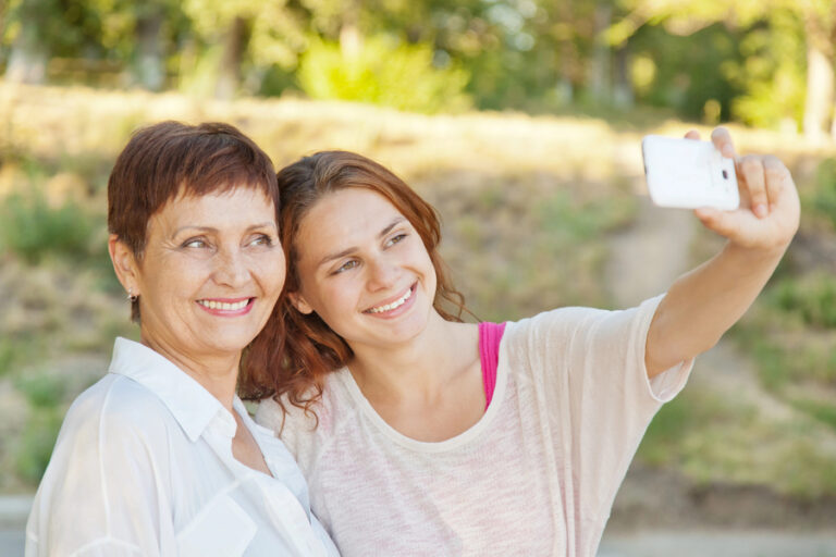 O que fazer no dia das mães: filha e mãe adultas tirando selfie