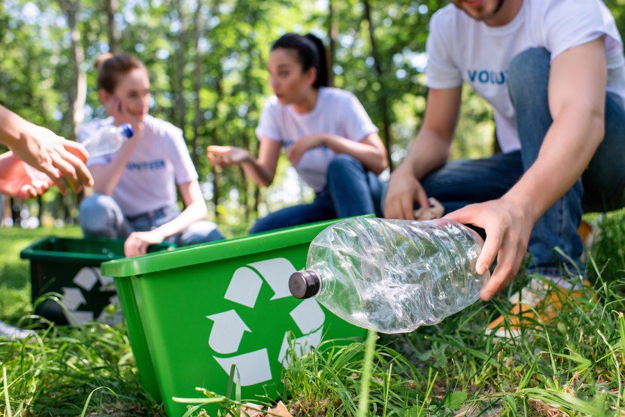 Jovens coletando plástico de área verde: responsabilidade ambiental